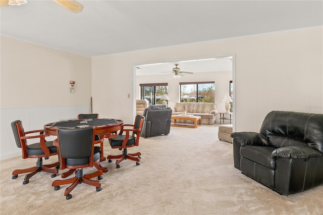 dining space with ornamental molding and light colored carpet