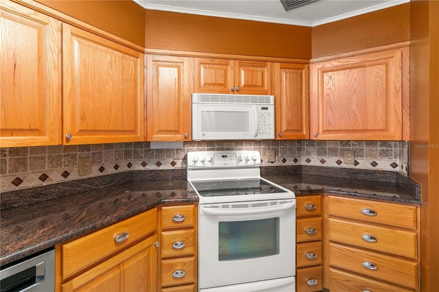 kitchen with dark stone countertops, backsplash, white appliances, and crown molding