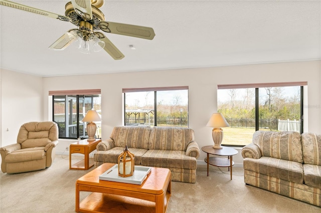 carpeted living room featuring ceiling fan