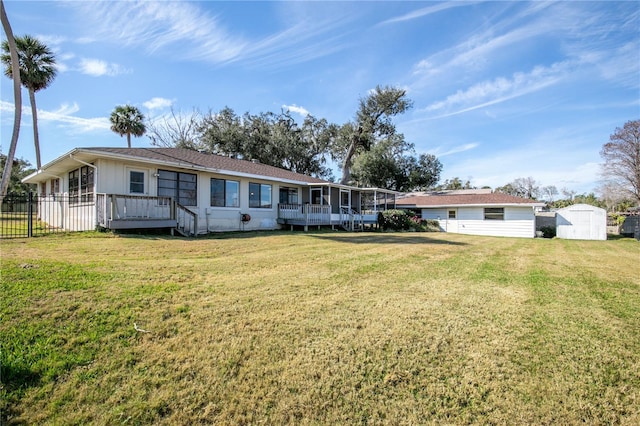 view of front of property with a wooden deck, a shed, and a front lawn