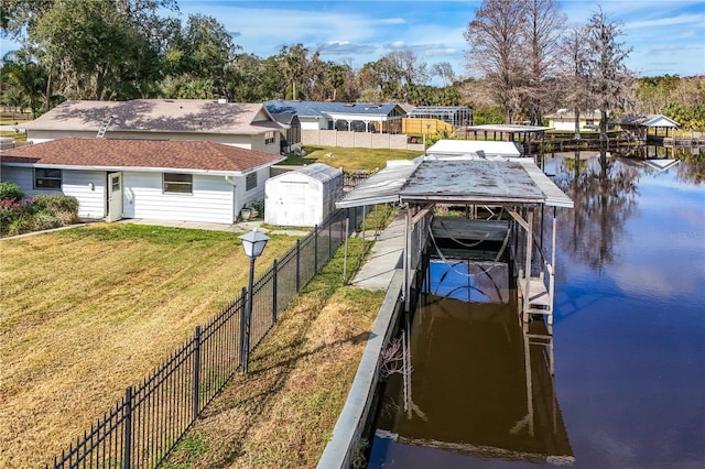 dock area with a lawn and a water view