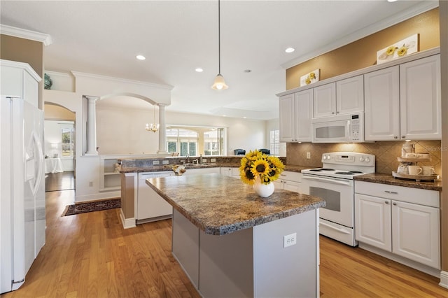 kitchen featuring a kitchen island, decorative light fixtures, white cabinets, white appliances, and light hardwood / wood-style flooring