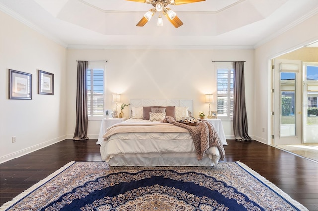 bedroom featuring ceiling fan, ornamental molding, dark hardwood / wood-style flooring, and a raised ceiling