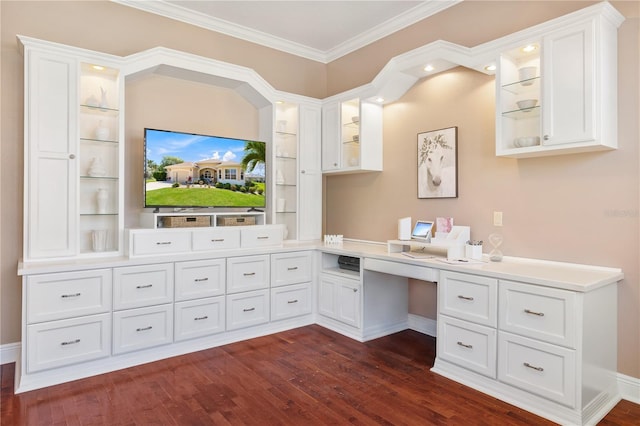 unfurnished office with ornamental molding, dark wood-type flooring, built in desk, and built in features