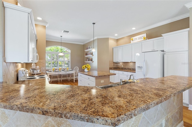 kitchen with sink, a center island, hanging light fixtures, ornamental molding, and white appliances