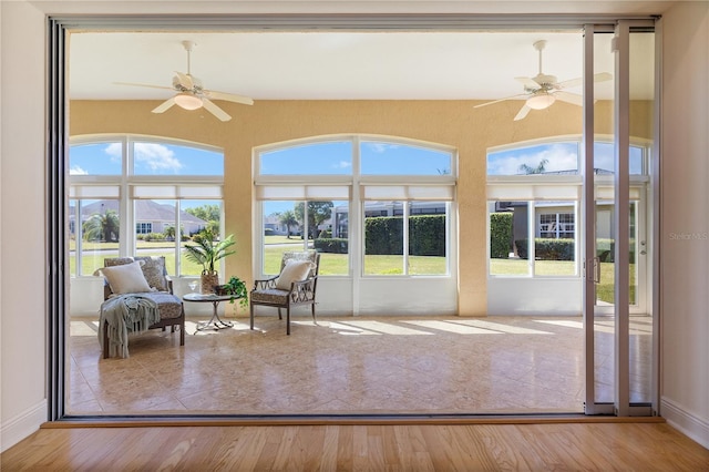 sunroom featuring ceiling fan and a healthy amount of sunlight