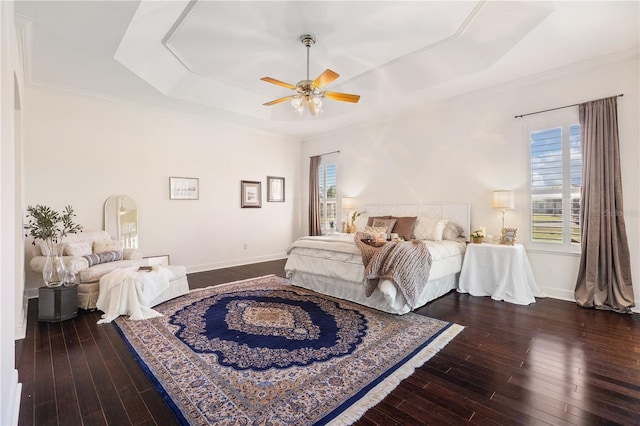 bedroom with a tray ceiling, wood-type flooring, ornamental molding, and ceiling fan