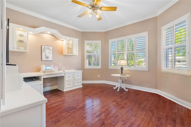 unfurnished office with dark wood-type flooring, ceiling fan, ornamental molding, and built in desk