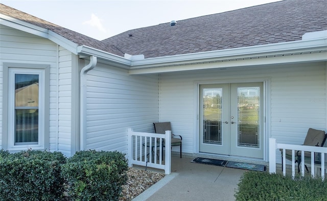 doorway to property with a shingled roof and french doors