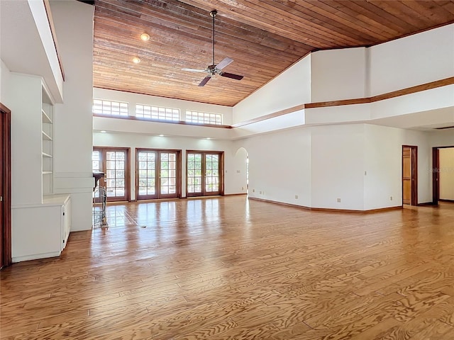 spare room featuring french doors, wooden ceiling, light wood-type flooring, ceiling fan, and a high ceiling