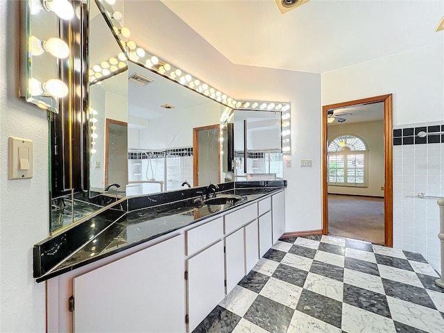 bathroom with vanity and tile walls