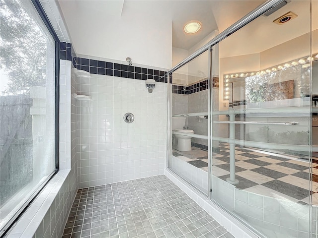 bathroom with tile walls, tile patterned floors, and a shower with shower door