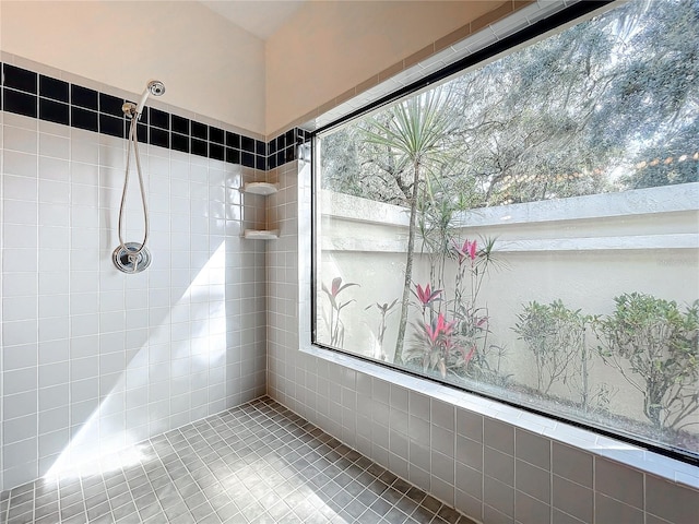 bathroom featuring tiled shower, tile patterned floors, and a wealth of natural light