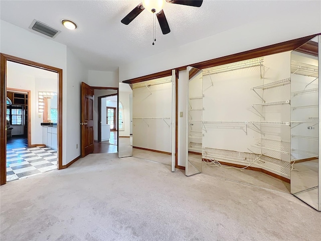 unfurnished bedroom with ensuite bath, ceiling fan, and carpet flooring