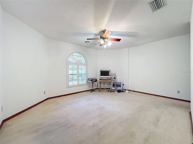 empty room featuring ceiling fan, carpet flooring, and a textured ceiling