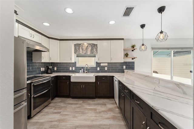 kitchen with white cabinetry, sink, decorative light fixtures, and appliances with stainless steel finishes