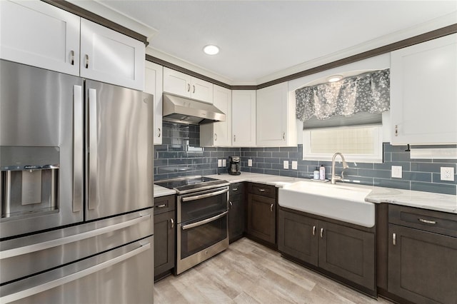 kitchen featuring white cabinetry, sink, decorative backsplash, and stainless steel appliances