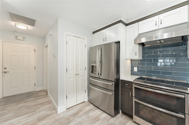 kitchen featuring tasteful backsplash, white cabinetry, appliances with stainless steel finishes, and light hardwood / wood-style floors