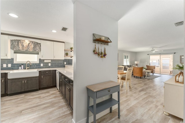 kitchen featuring dark brown cabinetry, sink, tasteful backsplash, light hardwood / wood-style floors, and white cabinets