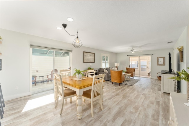 dining space with light hardwood / wood-style floors and ceiling fan