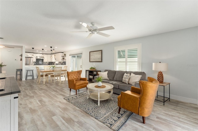 living room with ceiling fan and light wood-type flooring