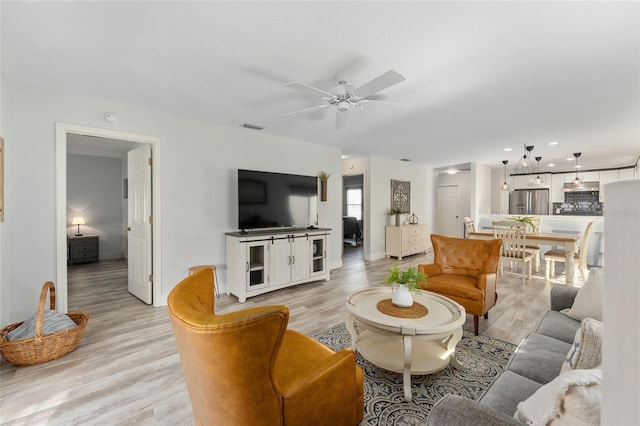 living room with light hardwood / wood-style floors and ceiling fan