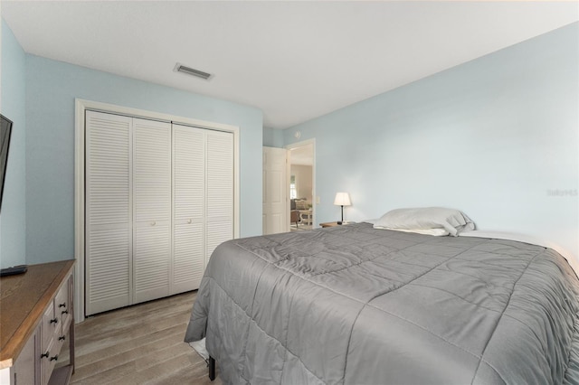 bedroom with light hardwood / wood-style flooring and a closet