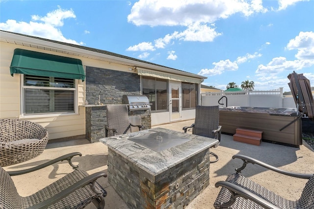 view of patio featuring a hot tub, an outdoor kitchen, a grill, and a sunroom