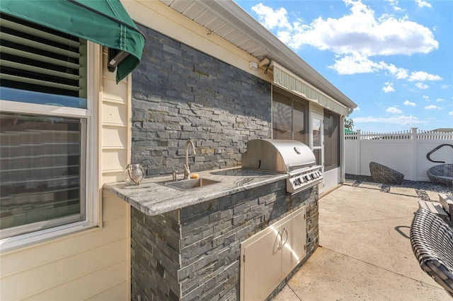 view of patio / terrace with an outdoor kitchen, a grill, and sink