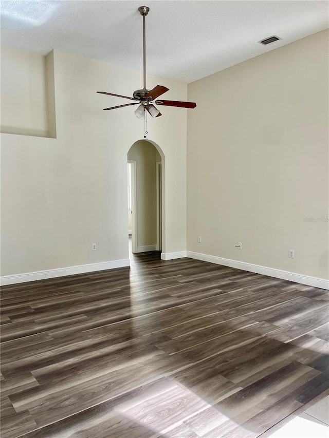 unfurnished room with ceiling fan, dark hardwood / wood-style flooring, and a textured ceiling