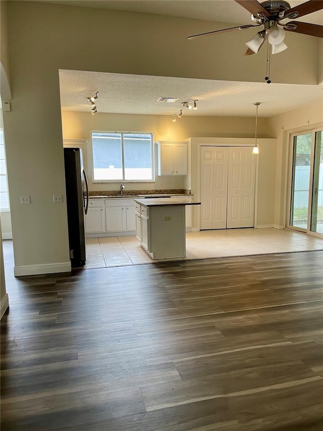 unfurnished living room featuring ceiling fan, sink, and light wood-type flooring