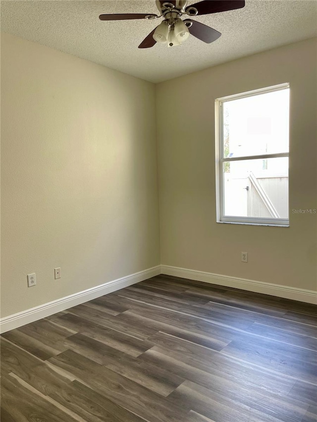 empty room with ceiling fan, a textured ceiling, and dark hardwood / wood-style floors