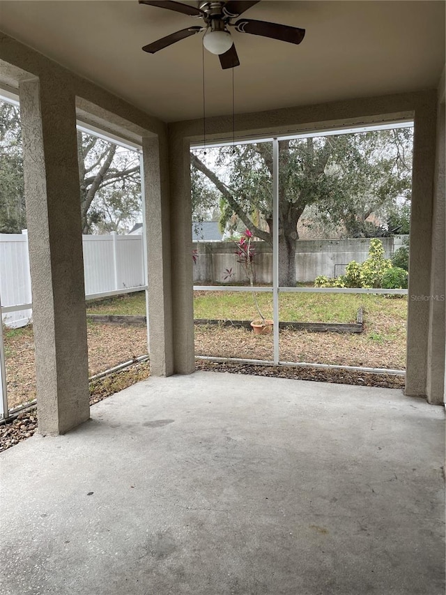 unfurnished sunroom with ceiling fan