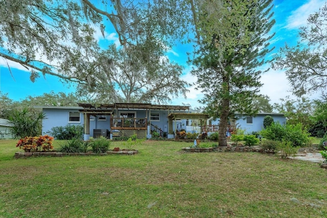 back of house with a wooden deck, a lawn, and a pergola