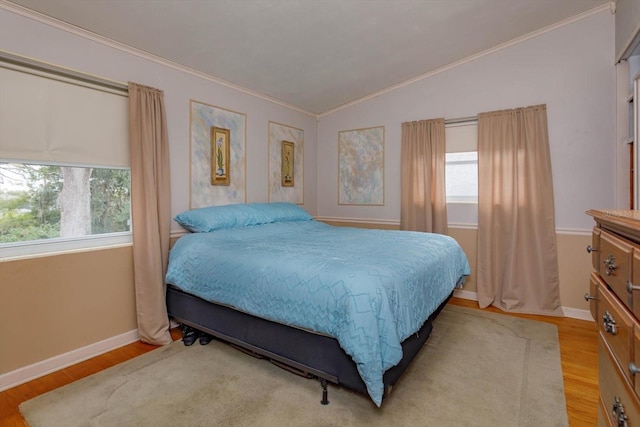 bedroom featuring ornamental molding, light hardwood / wood-style flooring, and lofted ceiling