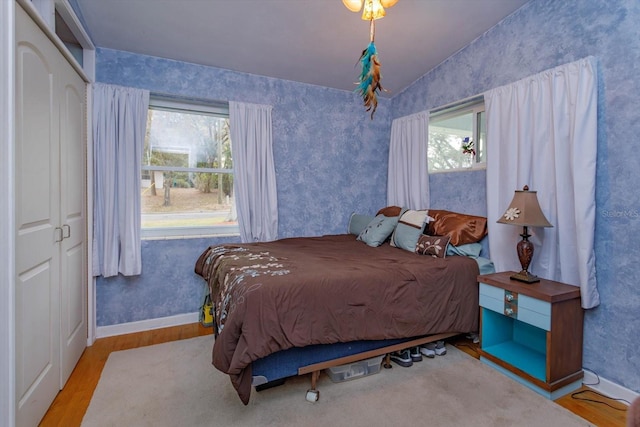 bedroom featuring wood-type flooring, a closet, and vaulted ceiling