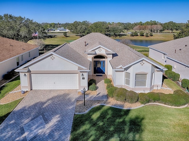 ranch-style house featuring a garage and a water view