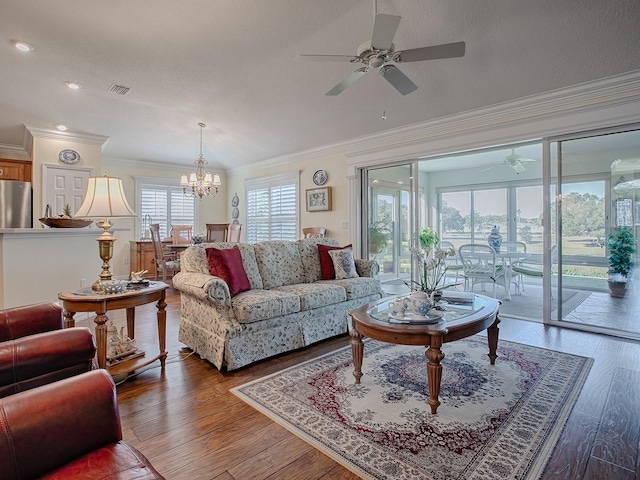 living room with hardwood / wood-style flooring, ceiling fan with notable chandelier, and ornamental molding