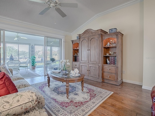 sitting room with vaulted ceiling, ornamental molding, a textured ceiling, and light wood-type flooring