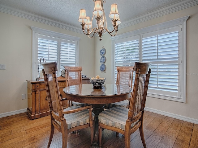 dining space with ornamental molding, a chandelier, a textured ceiling, and light wood-type flooring