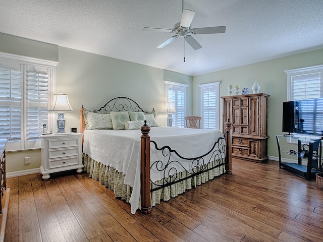 bedroom featuring wood-type flooring, a textured ceiling, and ceiling fan