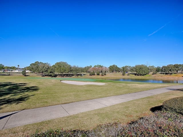 surrounding community with a yard and a water view