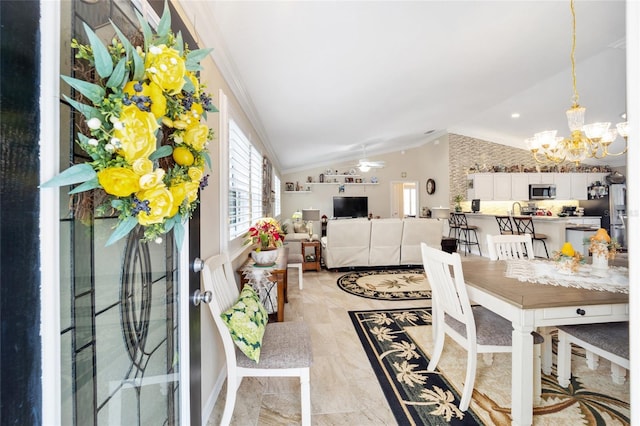 dining area featuring ceiling fan with notable chandelier, ornamental molding, and vaulted ceiling