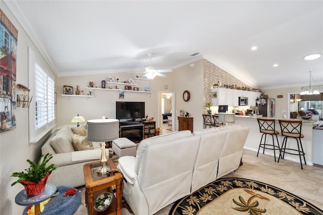 living room featuring vaulted ceiling, ceiling fan with notable chandelier, and ornamental molding