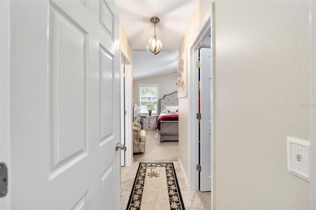 hallway featuring light carpet and vaulted ceiling