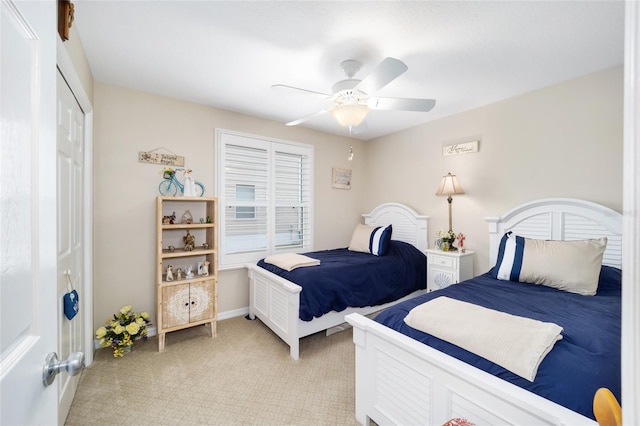 bedroom with baseboards, a ceiling fan, a closet, and light colored carpet