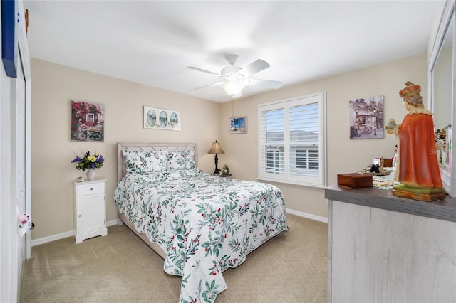 bedroom featuring light carpet, ceiling fan, and baseboards