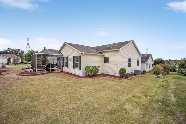 back of house with a lanai and a yard