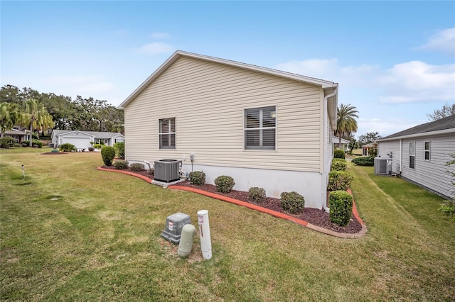 view of property exterior with a lawn and central AC unit