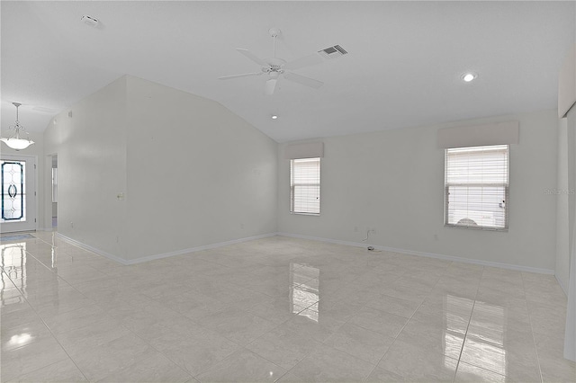 empty room with light tile patterned floors, vaulted ceiling, and ceiling fan